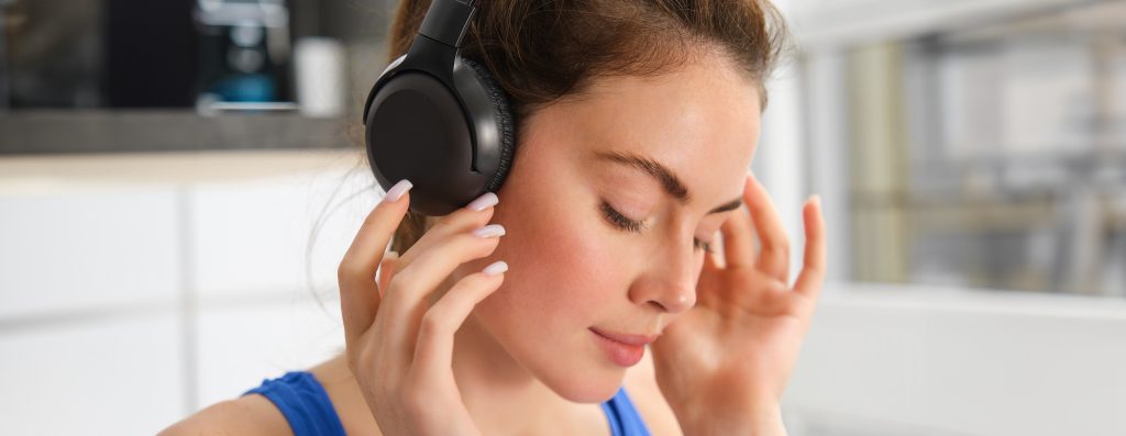 A beautiful woman wearing wireless headphones, enjoying her favorite music.