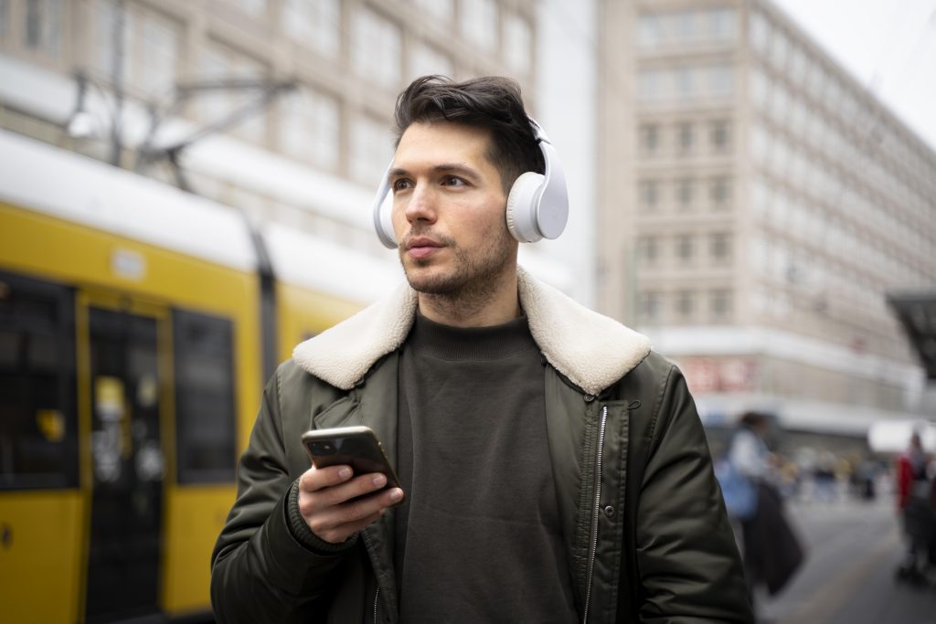 A person wearing Bose SoundLink on-ear headphones, commuting in a busy urban environment.